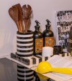 Modern çizgili mermer servis tepsisinde bir kitap, bir bıçak ve bir şişe yemeklik yağın bulunduğu mutfak tezgahı.