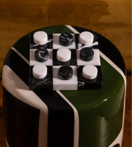 Ahşap parke üzerinde yer alan siyah beyaz kareli bir dama tahtası.